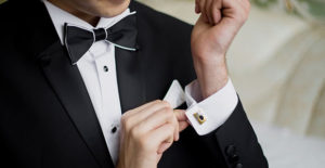 Man in Tux, adjusting cufflinks.