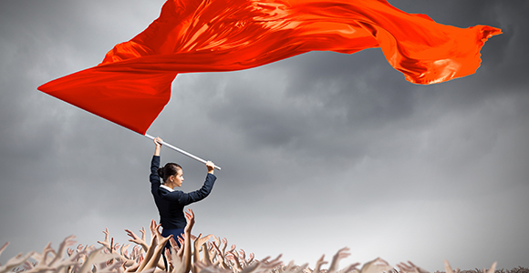 Woman standing above crowd waving red flag