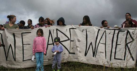 banner being held stating "we are water"