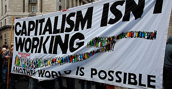 The banner reads: 'Capitalism isn't working: another world is possible'. G20, Meltdown Protest, City of London, Bank of England, 1 April 2009. Credit: Tony Hall.