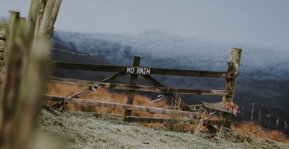 Picture of fence gate with sign that reads "no path."