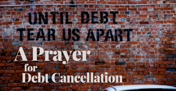 Brick wall with stenciled "Until Debt Tear Us Apart"
